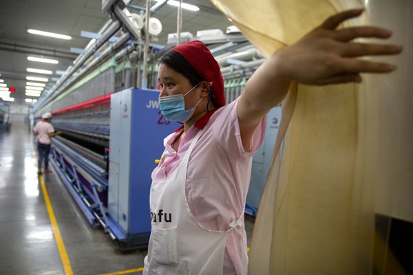 A worker at a Huafu Fashion plant during a government-organized trip for foreign journalists, in Aksu, Xinjiang Uyghur Autonomous Region, April 20, 2021 (AP photo by Mark Schiefelbein).