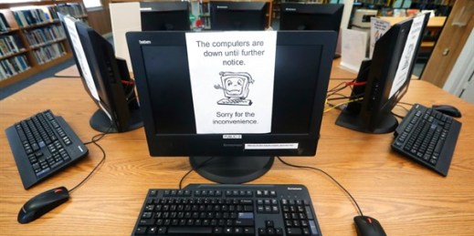 Signs on a bank of computers at the public library in Wilmer, Texas, tell visitors that the machines are not working, following a ransomware attack on local Texas governments’ networks, Aug. 22, 2019 (AP photo by Tony Gutierrez).