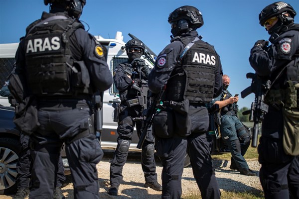 Members of the Lithuanian Police Anti-terrorist Operations Unit ARAS arrive at the refugee camp in the village of Vydeniai, Lithuania, July 10, 2021 (AP photo by Mindaugas Kulbis).