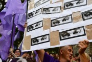 A man holds a banner showing the eyes of Hungarian Prime Minister Viktor Orban during a protest against the government’s alleged use of powerful spyware to spy on opponents, Budapest, Hungary, July 26, 2021 (AP photo by Anna Szilagyi).