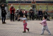 Older residents watching children play with bubbles at a residential compound in Beijing, Oct. 14, 2016 (AP file photo by Andy Wong).