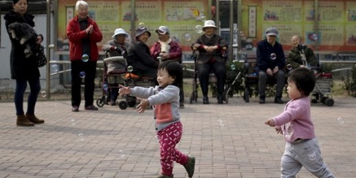 Older residents watching children play with bubbles at a residential compound in Beijing, Oct. 14, 2016 (AP file photo by Andy Wong).