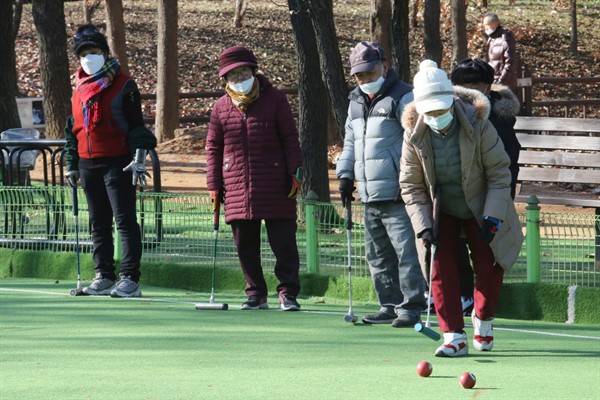 A group of elderly people play gate ball at a park in Goyang, South Korea, Nov. 28, 2020 (AP photo by Ahn Young-joon).