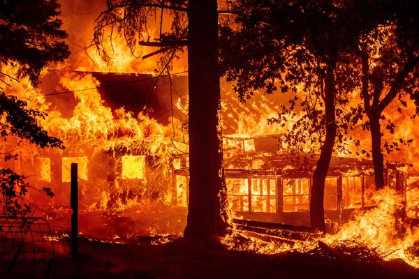 Flames from the Dixie Fire consume a home in the Indian Falls community of Plumas County, California, July 24, 2021 (AP photo by Noah Berger).