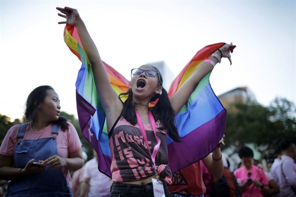 A student waves a rainbow flag while singing along to a concert performance at Pink Dot, an annual LGBT pride event, in Singapore, July 1, 2017 (AP photo by Wong Maye-E).