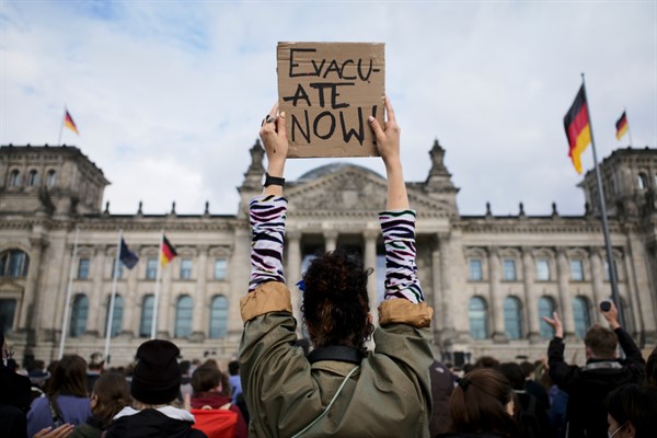 A woman holds a poster demanding the evacuation of people out of Afghanistan during a demonstration in Berlin, Germany, Aug. 17, 2021 (photo by Markus Schreiber).