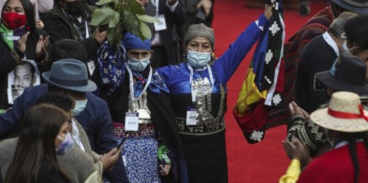 Elisa Loncon, president of the Constituent Assembly, raises an Indigenous Mapuche flag during the inaugural session of the Constitutional Convention in Santiago, Chile, July 4, 2021 (AP photo by Esteban Felix).