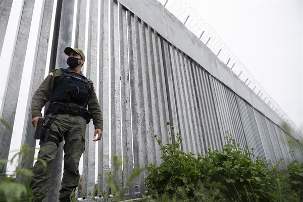 A police officer patrols alongside a steel wall at Evros river, near the village of Poros, at the Greek-Turkish border, Greece, May 21, 2021 (AP photo by Giannis Papanikos).
