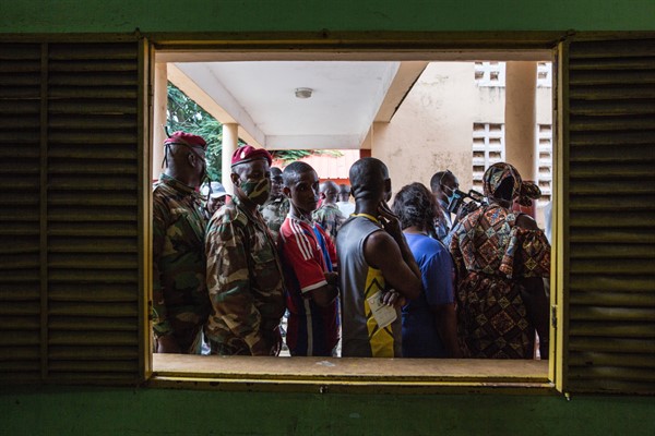 Civilians and soldiers line up to vote at a school in Conakry, Guinea, Oct. 18, 2020 (AP photo by Sadak Souici).