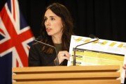 New Zealand Prime Minister Jacinda Ardern holds up a card showing a new alert system for COVID-19, in Wellington, New Zealand, March 21, 2020 (AP photo by Nick Perry).
