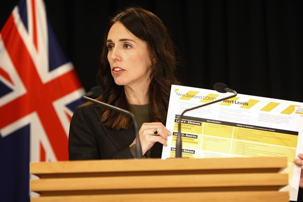 New Zealand Prime Minister Jacinda Ardern holds up a card showing a new alert system for COVID-19, in Wellington, New Zealand, March 21, 2020 (AP photo by Nick Perry).