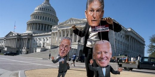 A climate change demonstrator mocks Sen. Joe Manchin, who has blocked President Joe Biden’s domestic agenda, at the Capitol in Washington, Oct. 20, 2021 (AP photo by J. Scott Applewhite).