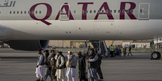 Taliban fighters walk past a Qatar Airways aircraft at the airport in Kabul, Afghanistan, Sept. 9, 2021 (AP photo by Bernat Armangue).