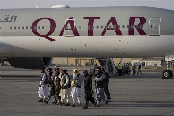 Taliban fighters walk past a Qatar Airways aircraft at the airport in Kabul, Afghanistan, Sept. 9, 2021 (AP photo by Bernat Armangue).