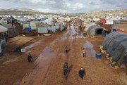 Syrian children walking through a camp for displaced people near the village of Kafr Aruq, in Idlib province, Syria, Jan. 28. 2021 (AP photo by Ghaith Alsayed).