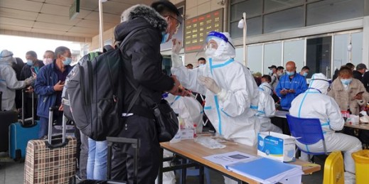 Medical workers take swab samples of arriving travelers at the exit of a railway station in Yantai, Shandong province, China, Nov. 2, 2021 (FeatureChina photo via AP Images).