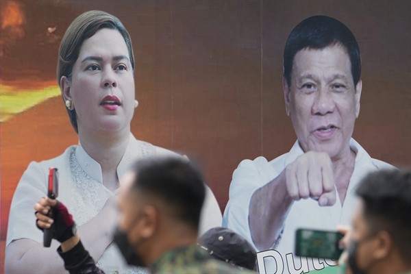 A vehicle bearing photos of Philippine President Rodrigo Duterte and his daughter, Davao City Mayor Sara Duterte, passes by the Commission on Elections in Manila, Philippines, Nov. 15, 2021 (AP photo by Aaron Favila).