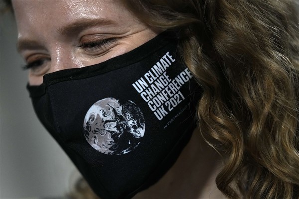 A delegate wears a face mask at the COP26 U.N. climate summit in Glasgow, Scotland, Oct. 31, 2021 (AP photo by Alastair Grant).