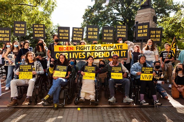 Demonstrators stand behind five people who are on a hunger strike for climate solutions, near the White House, Washington, Oct. 22, 2021 (photo by Allison Bailey for NurPhoto via AP).