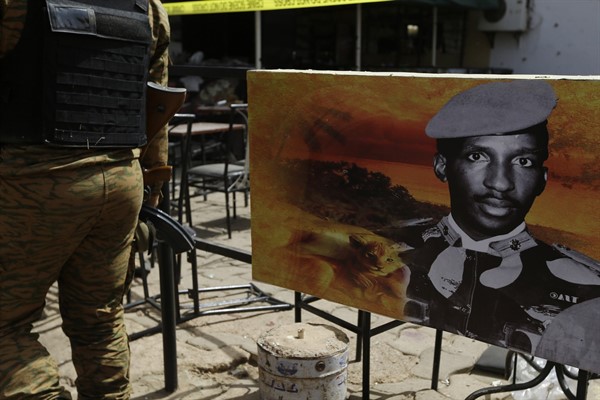 A soldier walks past a poster of Thomas Sankara outside a bar that was attacked by al-Qaida-linked extremists in Ouagadougou, Burkina Faso, Jan. 17, 2016 (AP photo by Sunday Alamba).