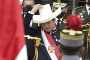 Peru's newly sworn-in president, Pedro Castillo, acknowledges the Peruvian flag held by soldiers outside Congress on his inauguration day in Lima, Peru, July 28, 2021 (AP photo by Francisco Rodriguez).