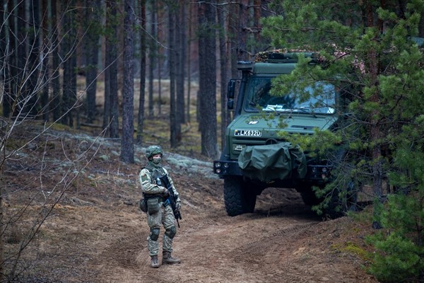 A Lithuanian soldier patrols a road near the Lithuania-Belarus border, Nov. 13, 2021 (AP photo by Mindaugas Kulbis).