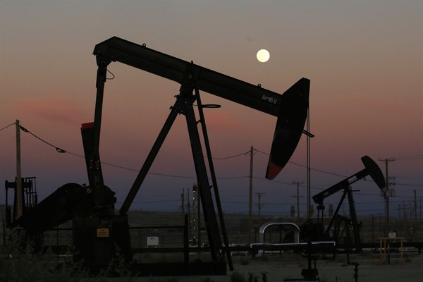 Oil derricks are busy pumping as the moon rises near the La Paloma Generating Station in McKittrick, Calif, June 8, 2017 (AP photo by Gary Kazanjian).