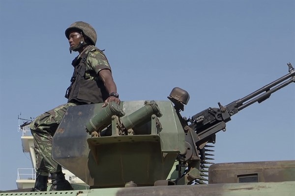 A Mozambican soldier rides on an armored vehicle at the airport in Mocimboa da Praia, Cabo Delgado province, Mozambique, Aug. 9, 2021 (AP photo by Marc Hoogsteyns).