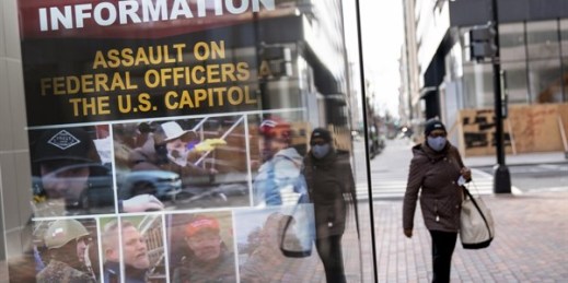 A billboard seeking information on persons involved with the assault at the Capitol is displayed at a bus stop in Washington, Jan. 17, 2021 (AP photo by David Goldman).