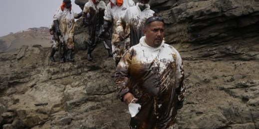 Workers are covered in oil after cleaning a spill at Cavero Beach in Ventanilla, a town near Callao, Peru, Jan. 21, 2022 (AP photo by Martin Mejia).