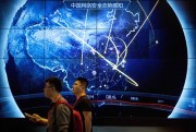 Attendees walk past an electronic display showing recent cyberattacks in China at the China Internet Security Conference in Beijing, Sept. 12, 2017 (AP photo by Mark Schiefelbein).