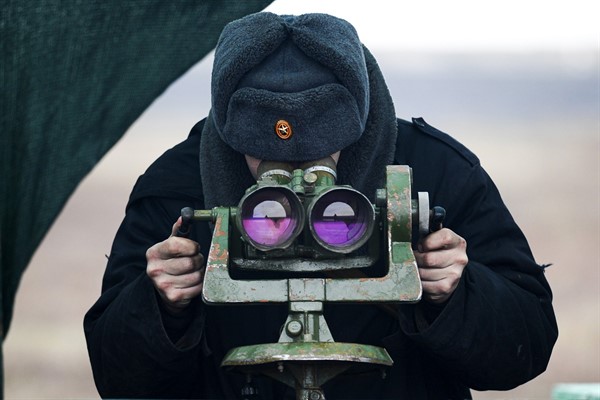 A Russian soldier looks through a binocular during drills in the Rostov region in southern Russia, Dec. 14, 2021 (AP photo).