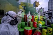 Environmental activists protest against the European Union’s “greenwashing” of nuclear energy under the Euro sculpture in Frankfurt, Germany, Jan. 11, 2022 (AP photo by Michael Probst).