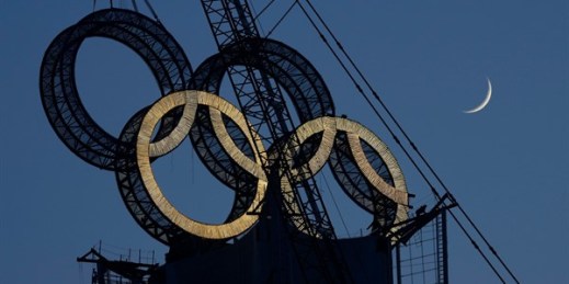Workers assemble the Olympic Rings onto a tower, Beijing, China, Jan. 5, 2022 (AP photo by Ng Han Guan).