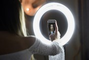 Matty Nev Luby holds up her phone in front of a ring light she uses to lip-sync with the smartphone app Musical.ly, in Wethersfield, Conn., Feb. 28, 2018 (AP photo by Jessica Hill).