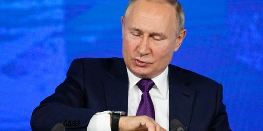 Russian President Vladimir Putin looks at his watch at the end of his annual news conference in Moscow, Russia, Dec. 23, 2021 (AP photo by Alexander Zemlianichenko).