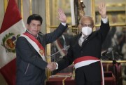 Peruvian President Pedro Castillo, left, waves alongside his new chief of Cabinet, Anibal Torres, during the swearing-in ceremony for his new Cabinet at the government palace in Lima, Peru, Feb. 8, 2022 (AP photo by Martin Mejia).