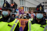 Police officers accompany climate activists as they take part in a protest through the streets of London, Nov. 6, 2021 (AP photo by David Cliff).