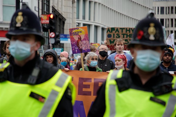 Police officers accompany climate activists as they take part in a protest through the streets of London, Nov. 6, 2021 (AP photo by David Cliff).