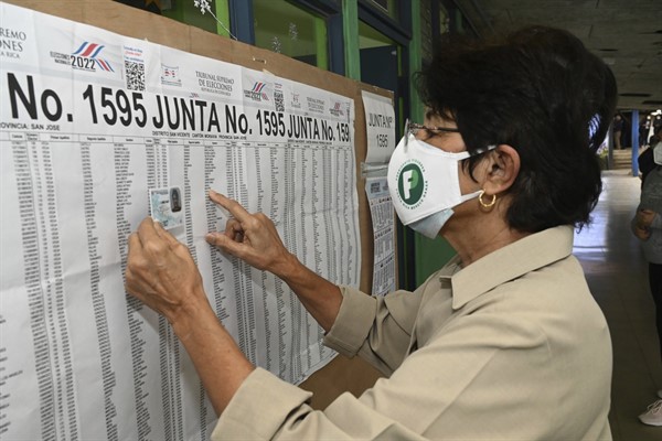 Maryory Vega checks her name on a voting roster during general elections, at a voting center at the Liceo de Moravia school in San Jose, Costa Rica, Feb. 6, 2022 (AP photo by Carlos Gonzalez).