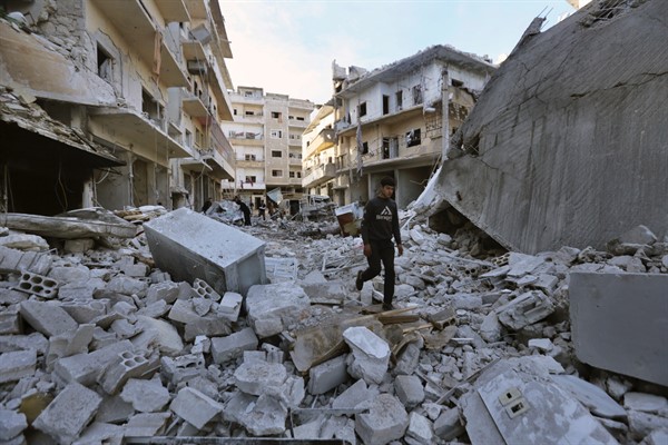A man walks past destruction resulting from airstrikes on the town of Ariha, in Idlib province, Syria, Jan. 30, 2020 (AP photo by Ghaith Alsayed).