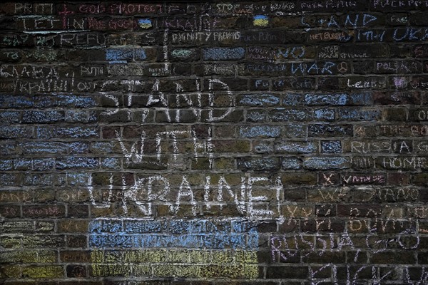 Messages protesting against the war in Ukraine chalked on the wall surrounding the Russian Embassy in London, March 11, 2022 (AP photo by Frank Augstein).
