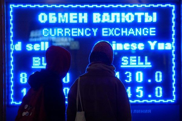 Women look at a screen displaying exchange rates at a currency exchange office in St. Petersburg, Russia, March 1, 2022 (AP photo by Dmitri Lovetsky).