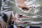 A ripped electoral poster of French President Emmanuel Macron is displayed in Lyon, France, April 22, 2022 (AP photo by Laurent Cipriani).
