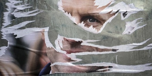A ripped electoral poster of French President Emmanuel Macron is displayed in Lyon, France, April 22, 2022 (AP photo by Laurent Cipriani).