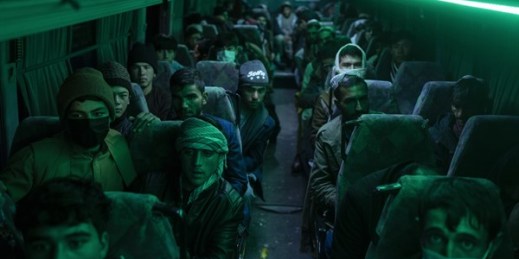 Afghan men sit in a bus ahead of a 300-mile trip south to Nimrooz near the Iranian border, Herat, Afghanistan, Nov. 22, 2021 (AP photo by Petros Giannakouris).