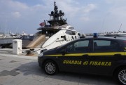 An Italian Finance Police car is parked in front of the yacht “Lady M,” owned by Russian oligarch Alexei Mordashov, docked at Imperia’s harbor, Italy, March 5, 2022 (AP photo by Antonio Calanni).