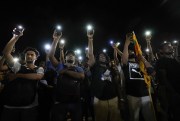 Sri Lankans hold up their mobile phone torches during a vigil outside the president’s office to condemn police shootings of protesters, Colombo, Sri Lanka, April 19, 2022 (AP photo by Eranga Jayawardena).