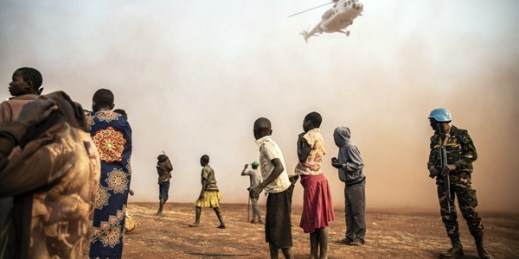 Displaced people watch a helicopter carrying U.N. Undersecretary-General for Peace Operations Jean Pierre Lacroix land in Bunia, eastern Congo, Feb. 22, 2022 (AP photo by Moses Sawasawa).