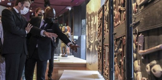 French President Emmanuel Macron looks at Beninese art during a ceremony for the return of 26 works to Benin, with Benin Culture Minister Roselyne Bachelot-Narquin, at the Quai Branly Museum-Jacques Chirac, Paris, October 27, 2021 (Sipa via AP Images).